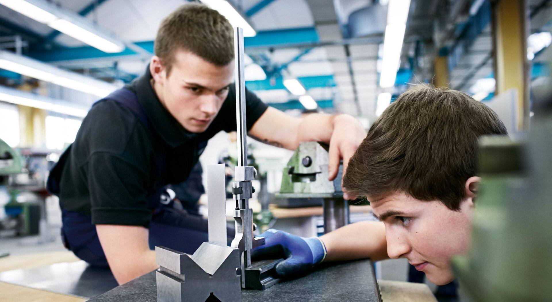 The picture shows two students working very precisely during their internship at BMW.