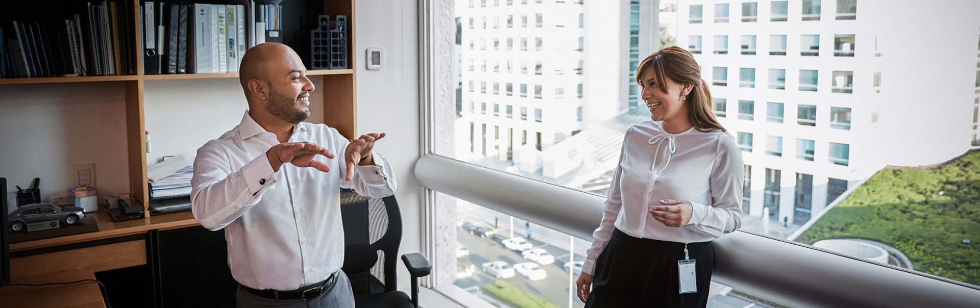 The picture shows two BMW marketing employees, a man and a woman having a discussion in an office.
