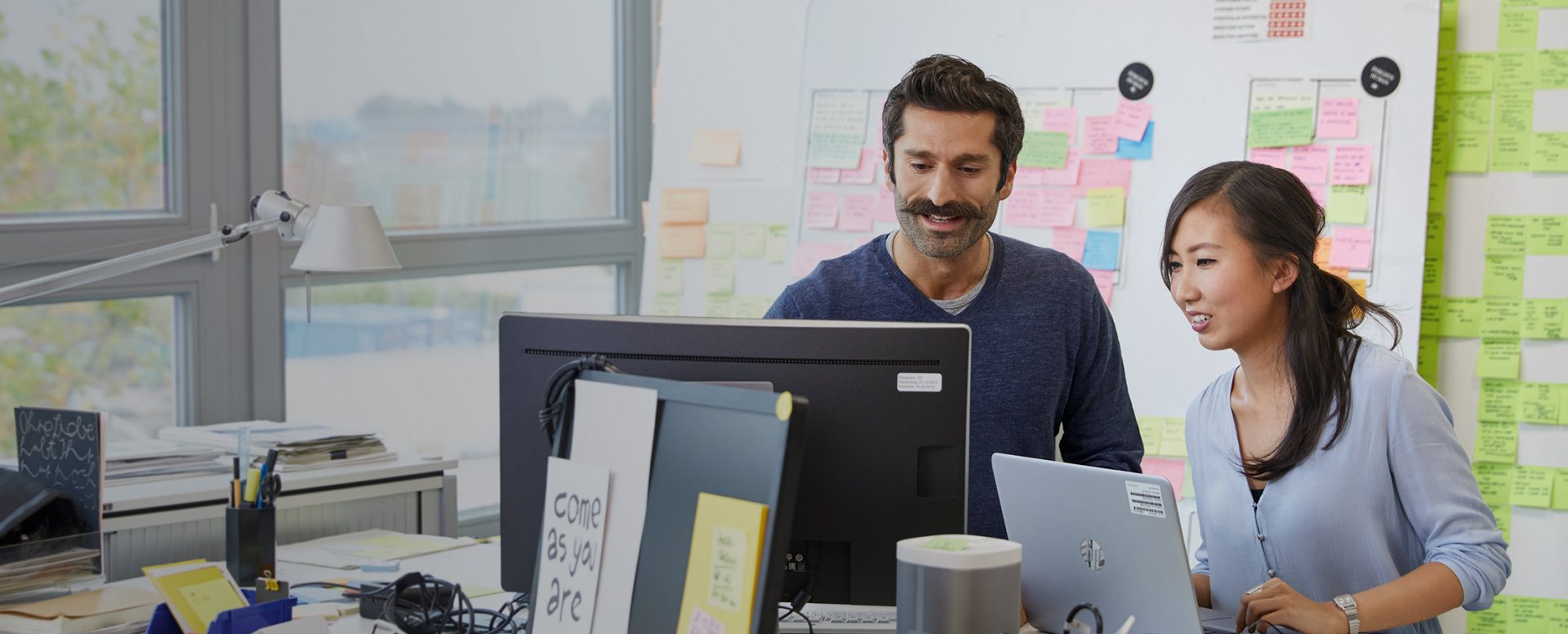 Two colleagues working behind their computers.