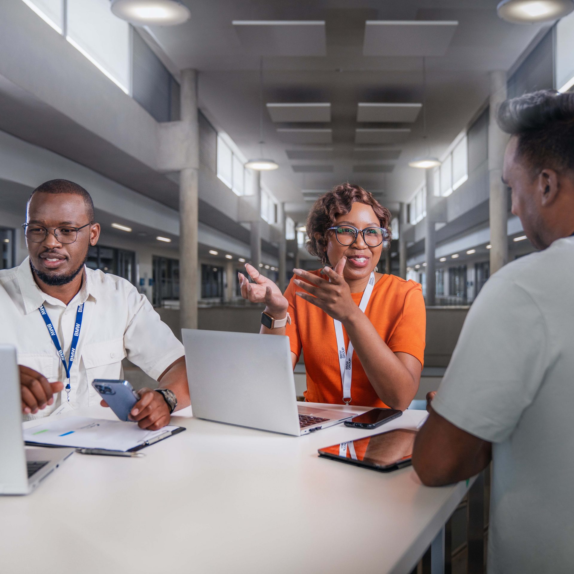 Three colleagues are having a conversation in the office