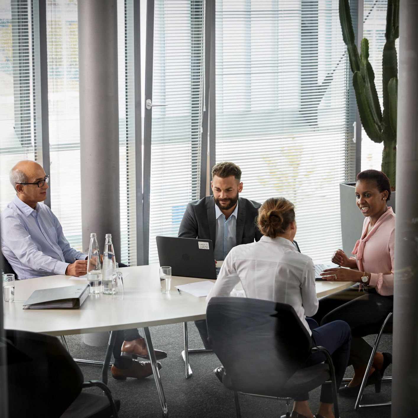 The image shows a group of employees in a meeting situation.