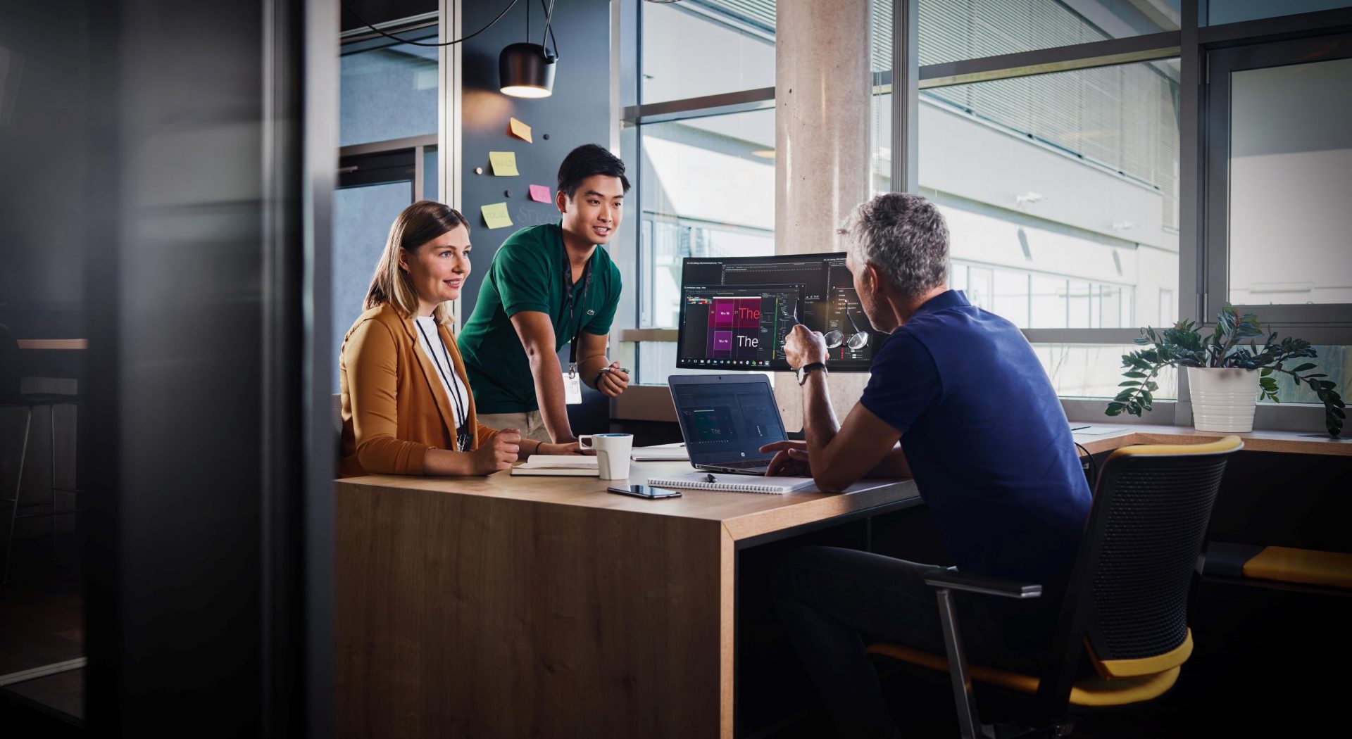 Three BMW professionals, a female one and two male ones, are meeting in an office to discuss a new project.