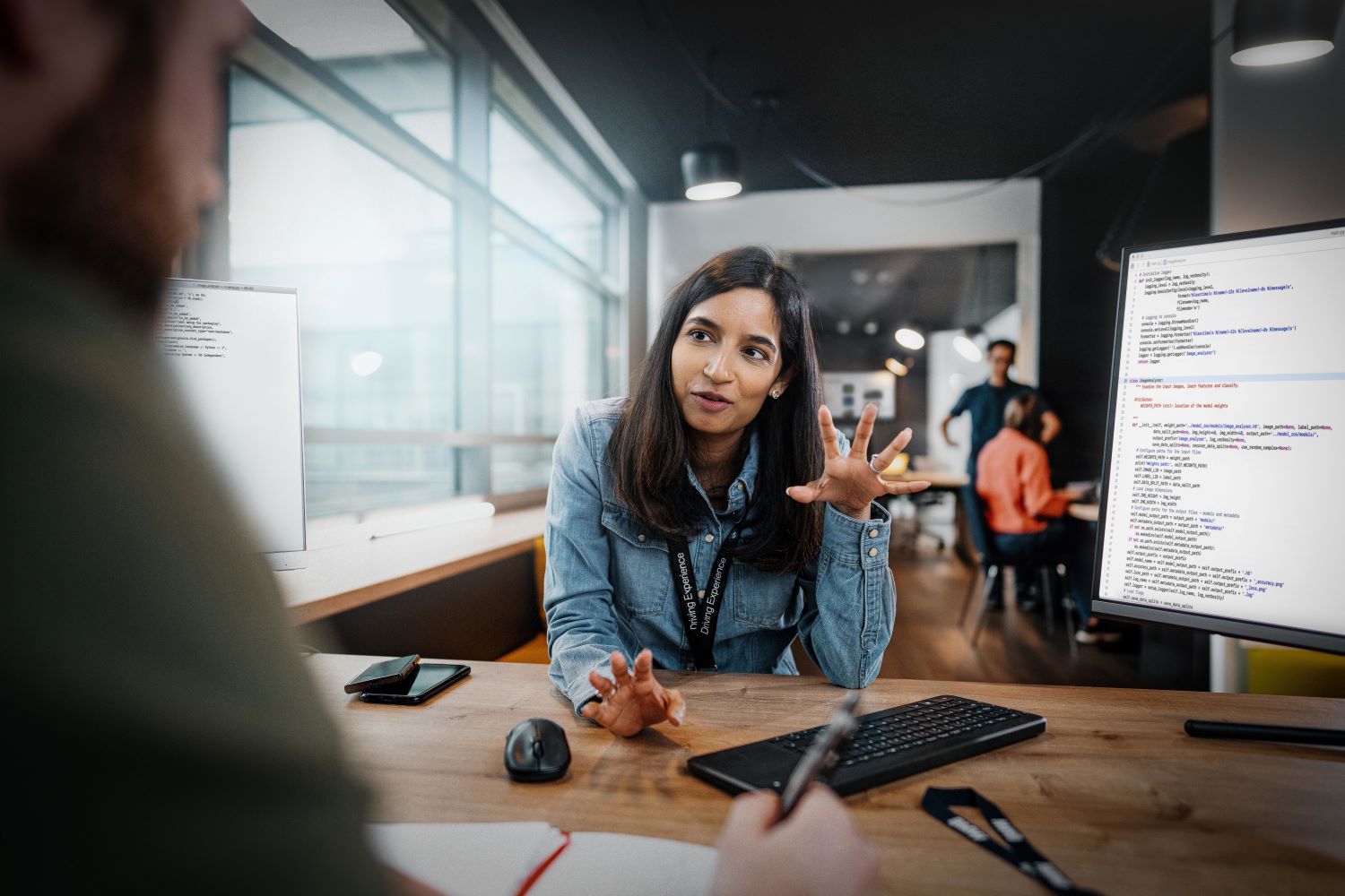 A woman discussing a work topic with her colleague.