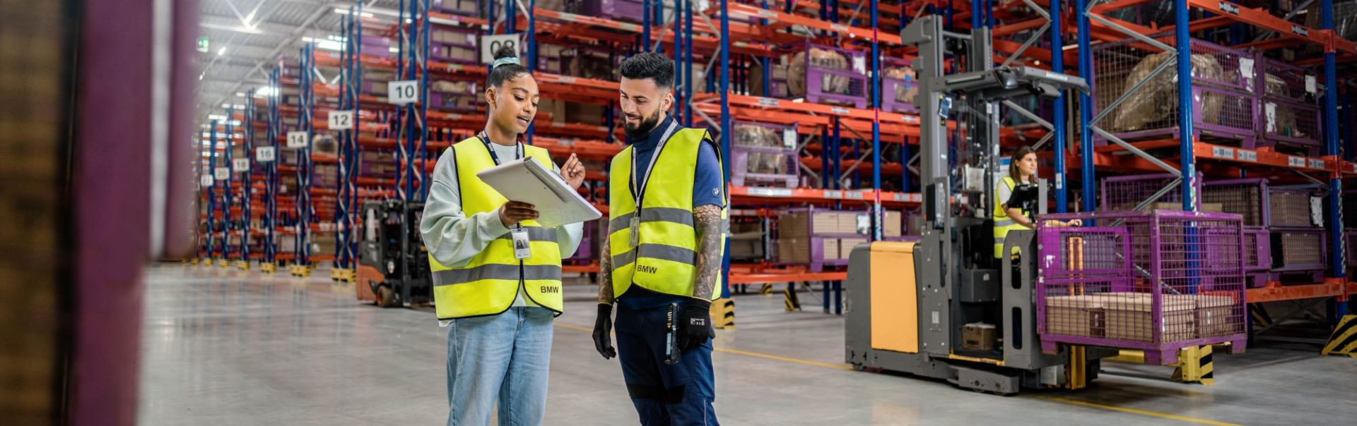 Two colleagues are standing in a BMW warehouse.