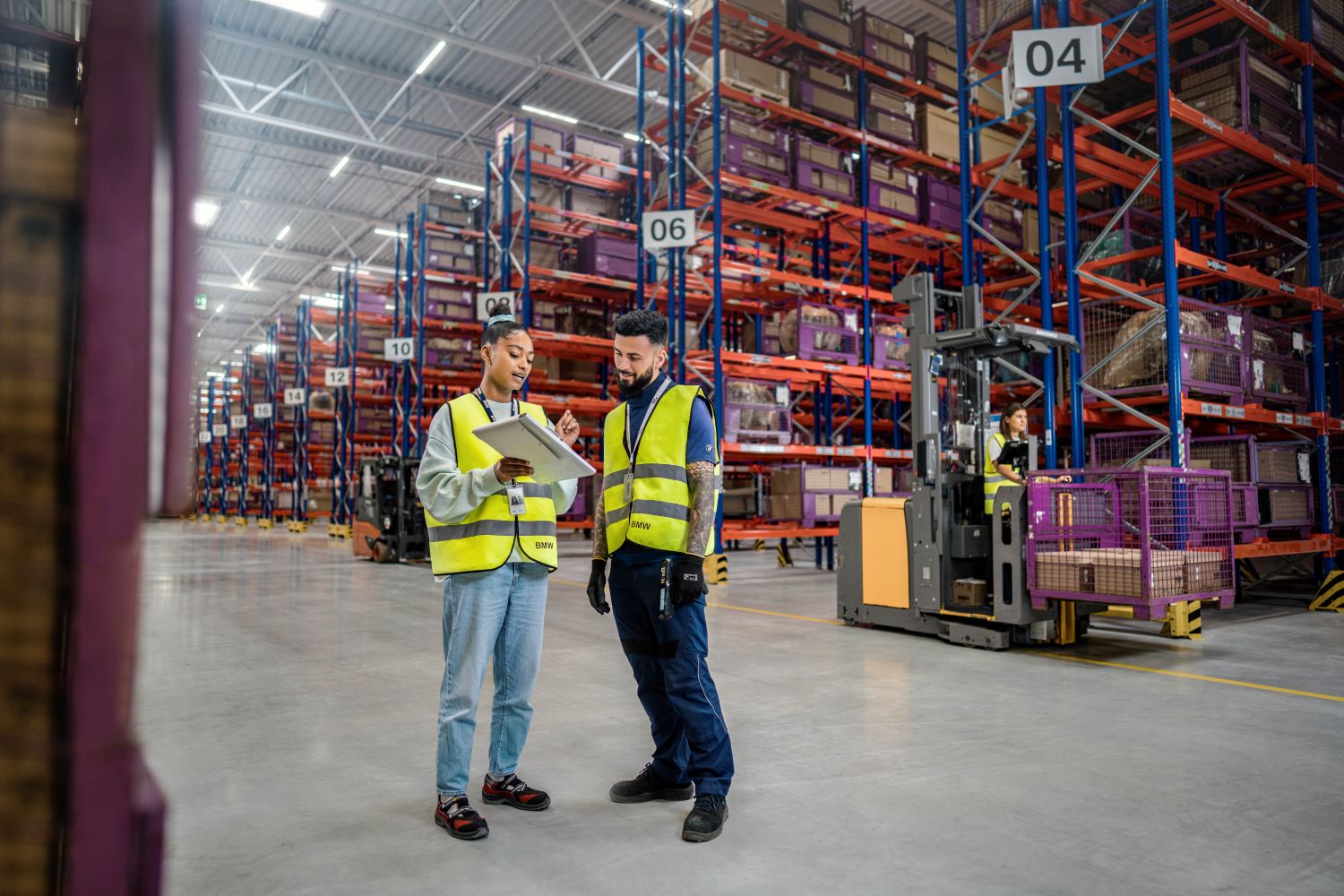 Two colleagues are standing in a BMW warehouse.