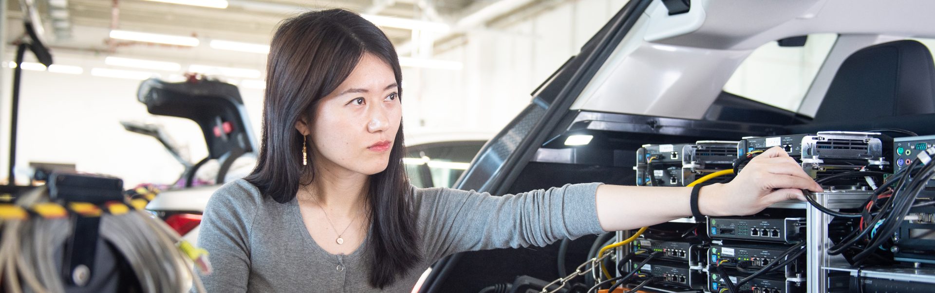 The image shows a BMW Group R&D employee at work.