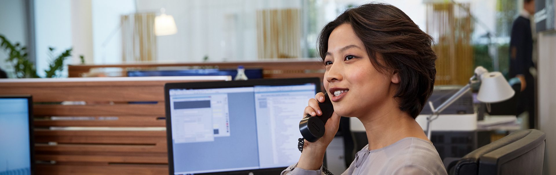 A woman who works in service and administration is on the phone answering some work-related questions.