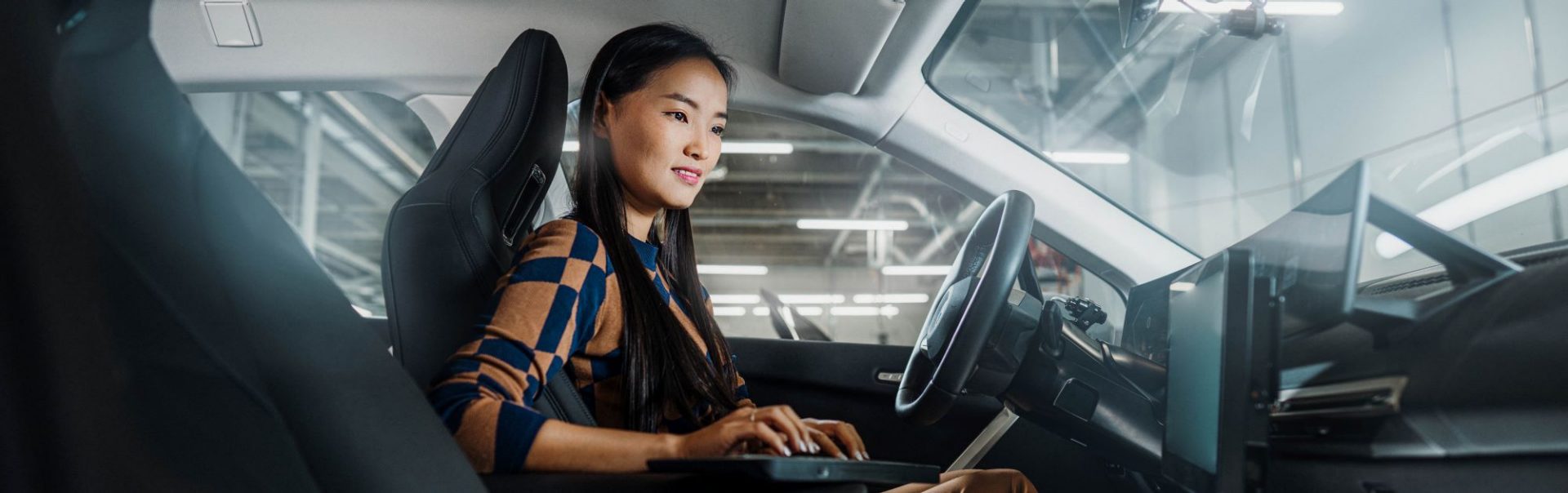 A women who works in Software Development is testing software in a BMW car.
