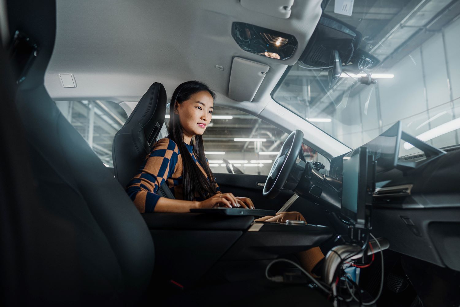 A women who works in Software Development is testing software in a BMW car.