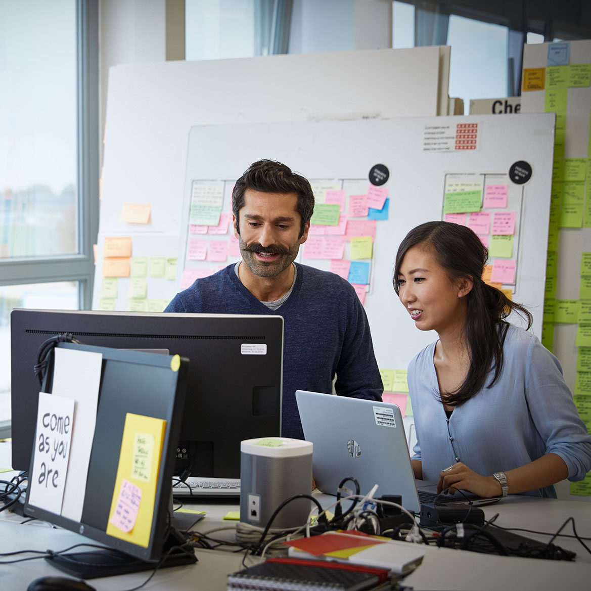 The image shows two BMW Group employees having a meeting.