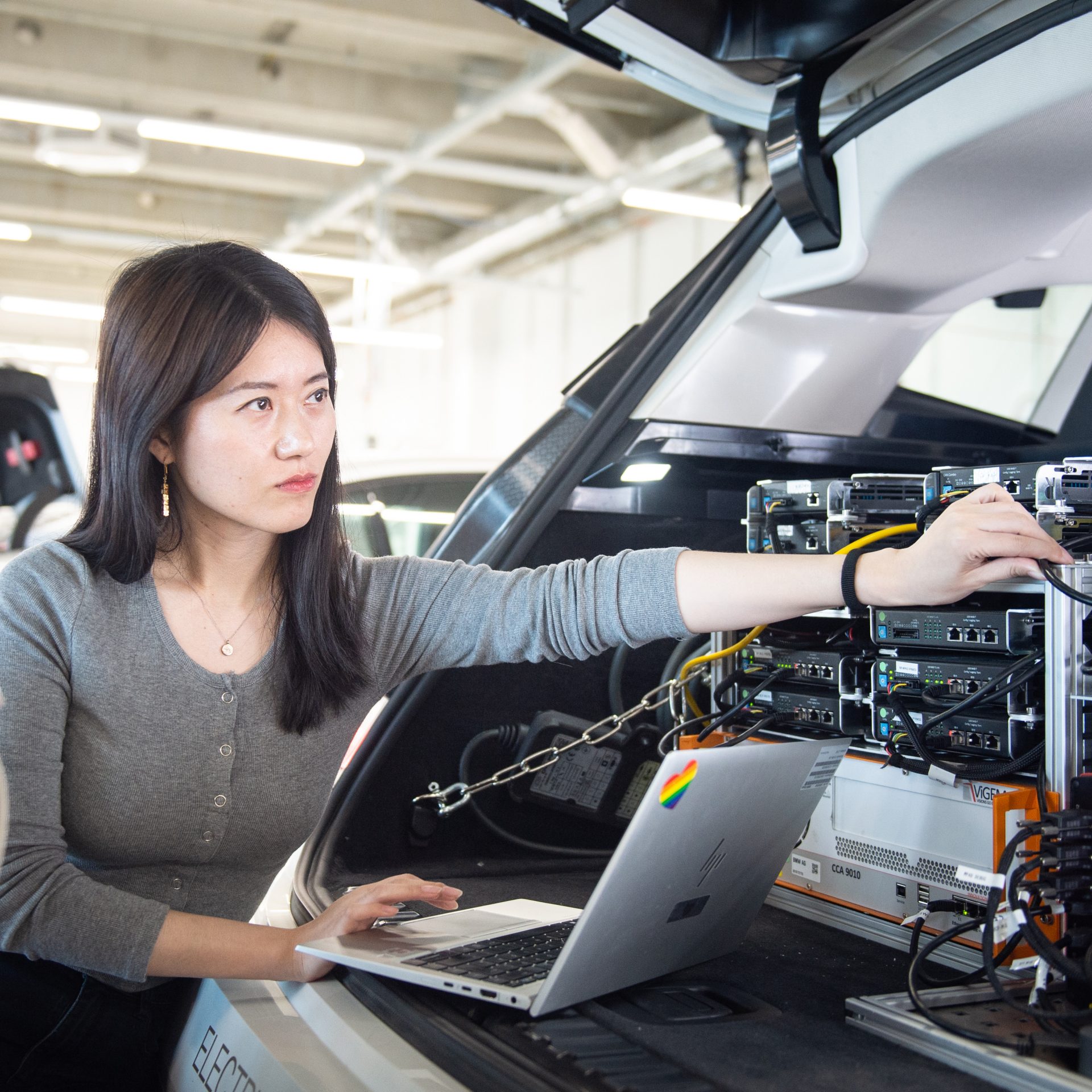 The image shows a BMW Group R&D employee at work.