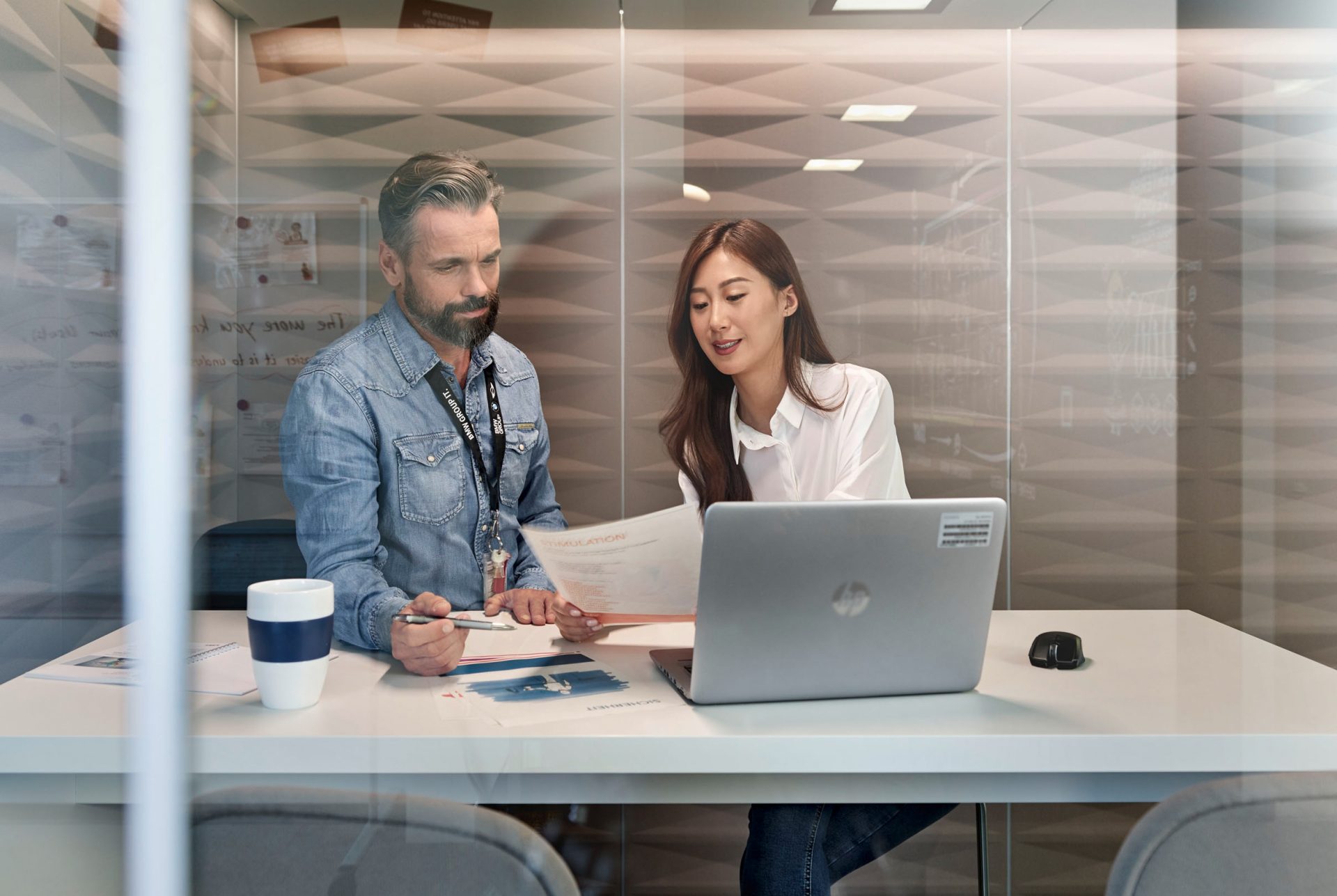 The image shows two colleagues in a meeting.