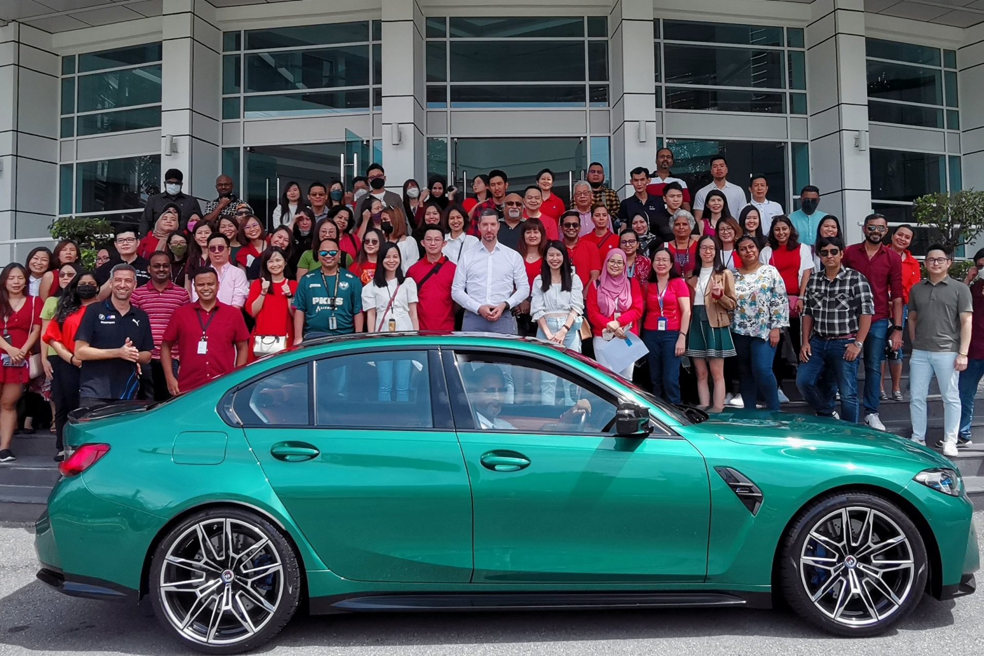 A group of BMW Group Malaysia colleagues in front of the office building.