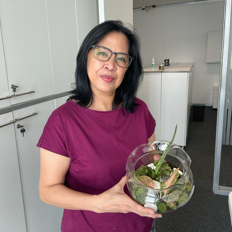 BMW Group Indonesia employee holding a plant. 