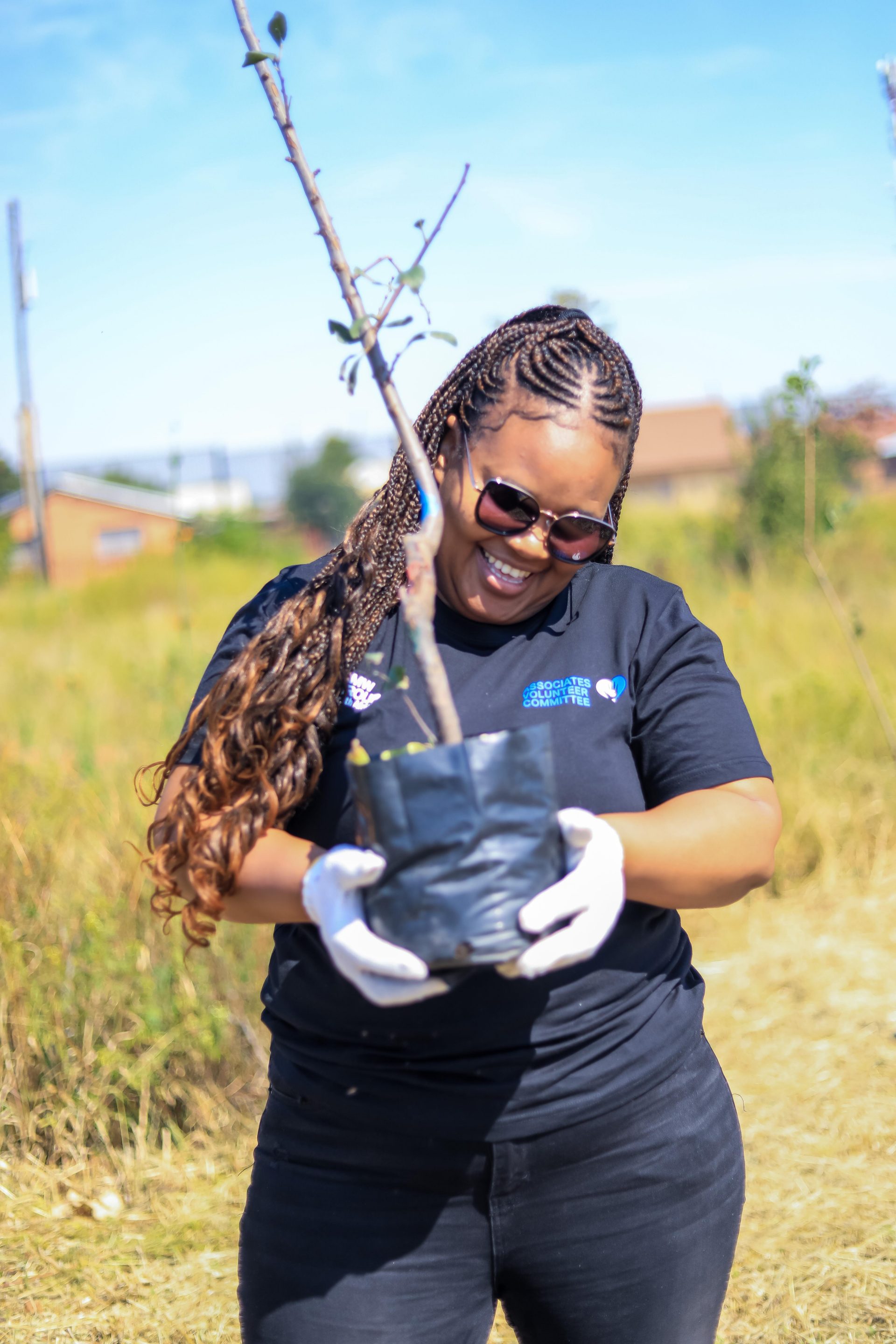 BMW Group South Africa employee holding a tree. 