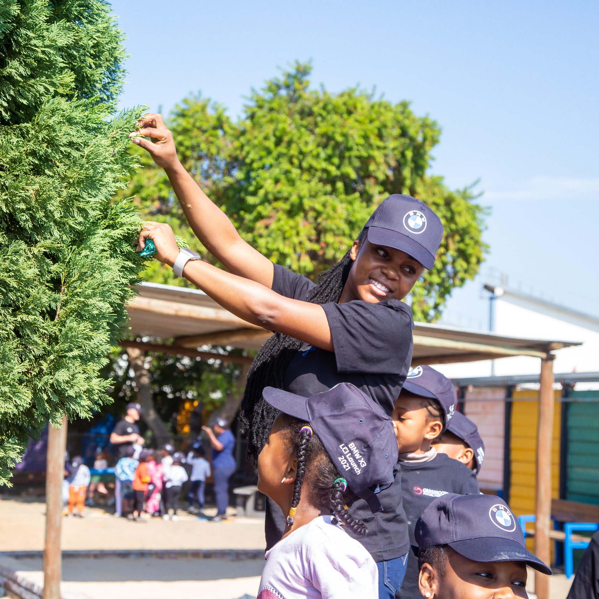 BMW Group South Africa employee cutting a branch of a tree.