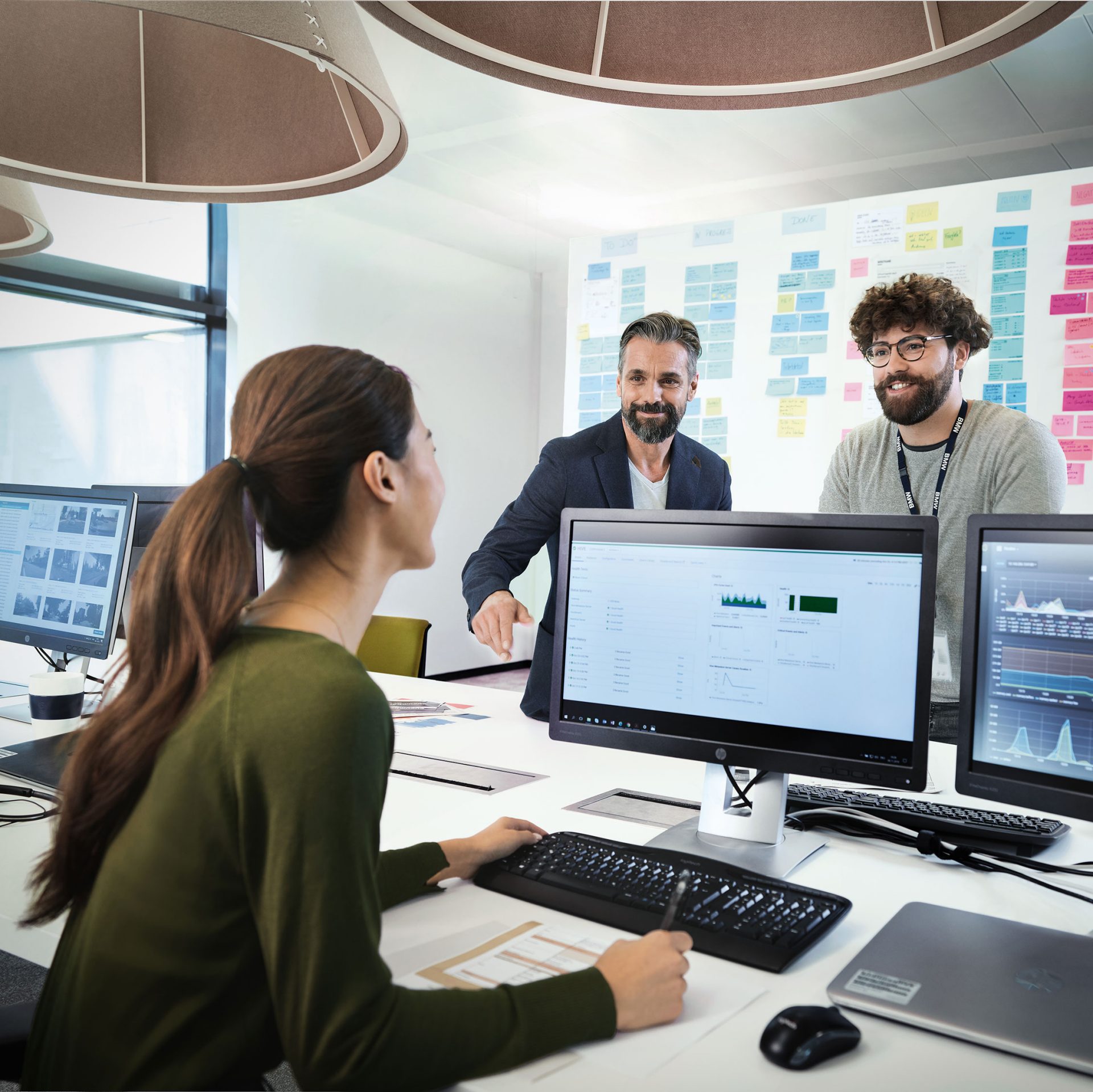 Das Bild zeigt drei BMW Kollegen im Austausch.