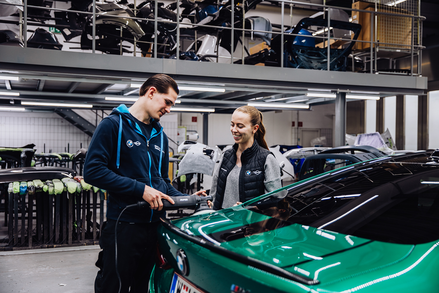 Karosseriebau-Lehrling mit Ausbilderin beim Polieren eines BMW M4