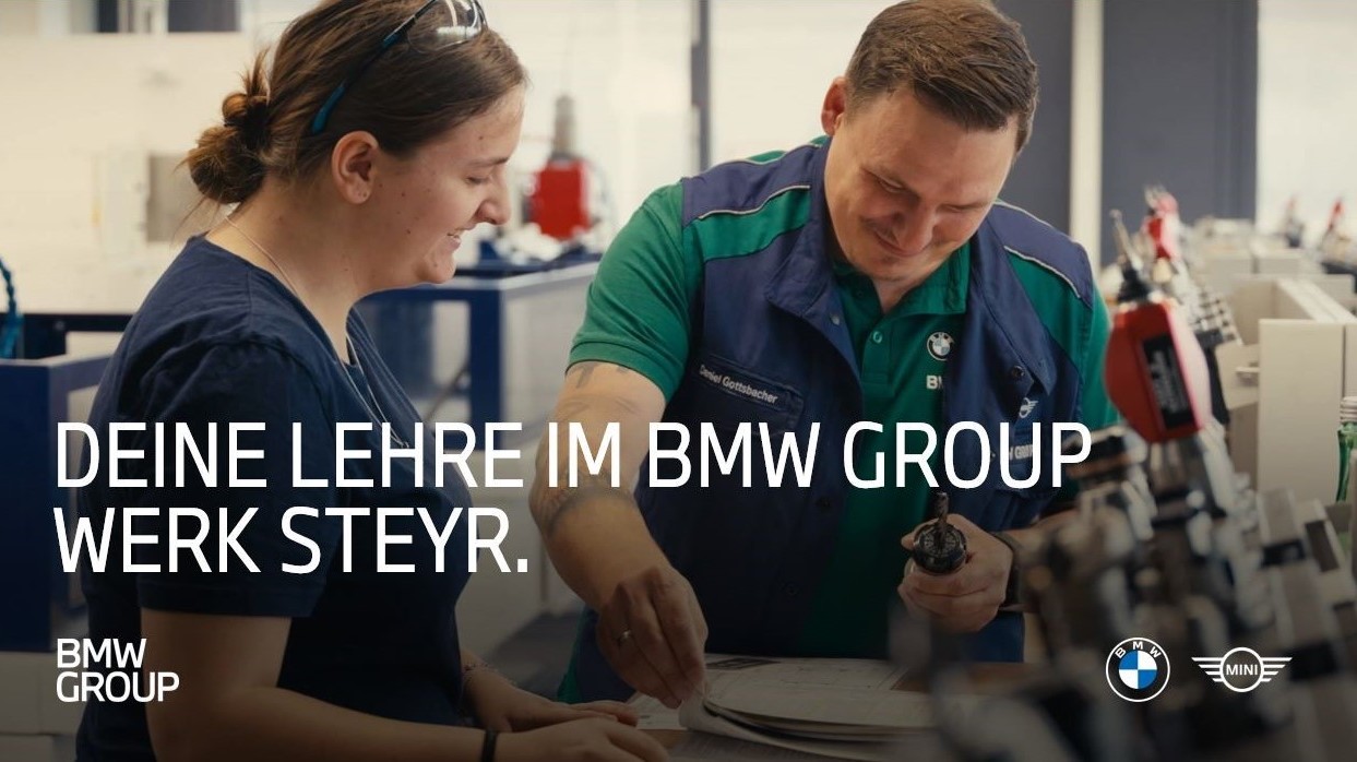 Lehrling mit Lehrmeister bei der Arbeit an einer Maschine