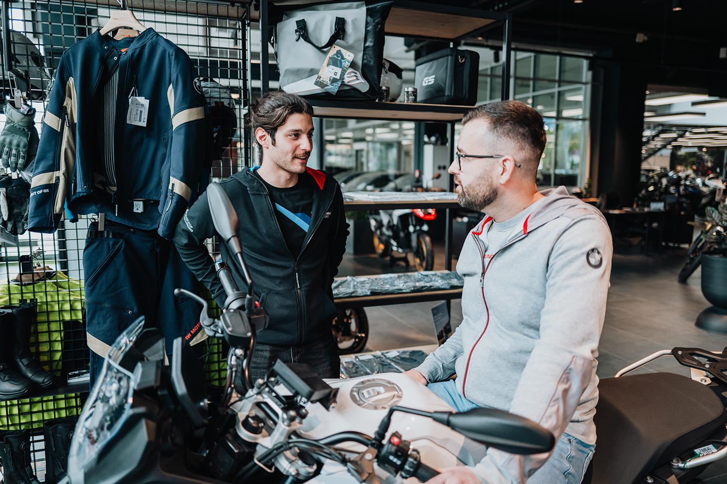 Serviceberater Kaan im Gespräch mit einem Kunden auf einem BMW Motorrad