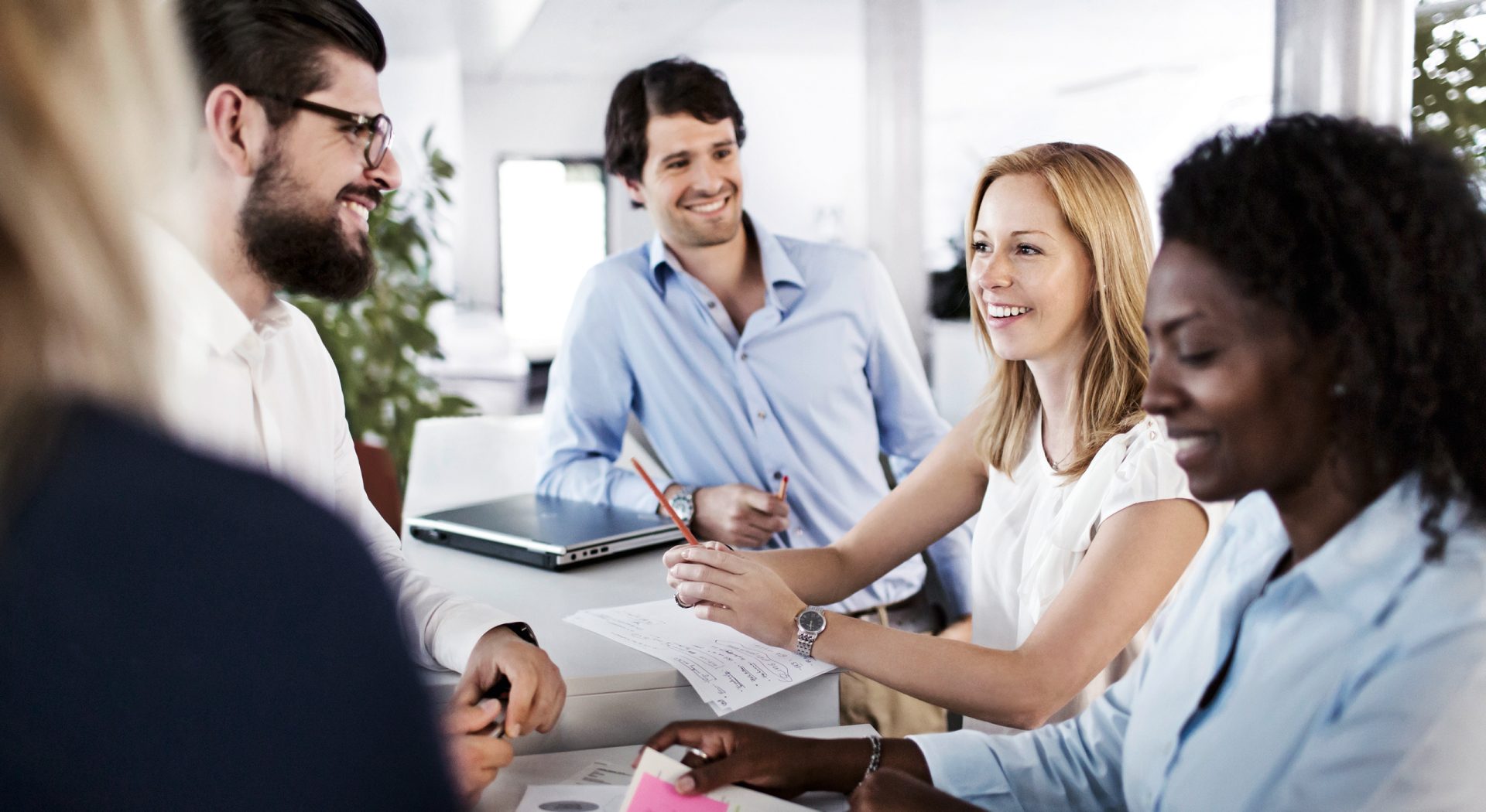 The picture shows colleagues in a meeting.