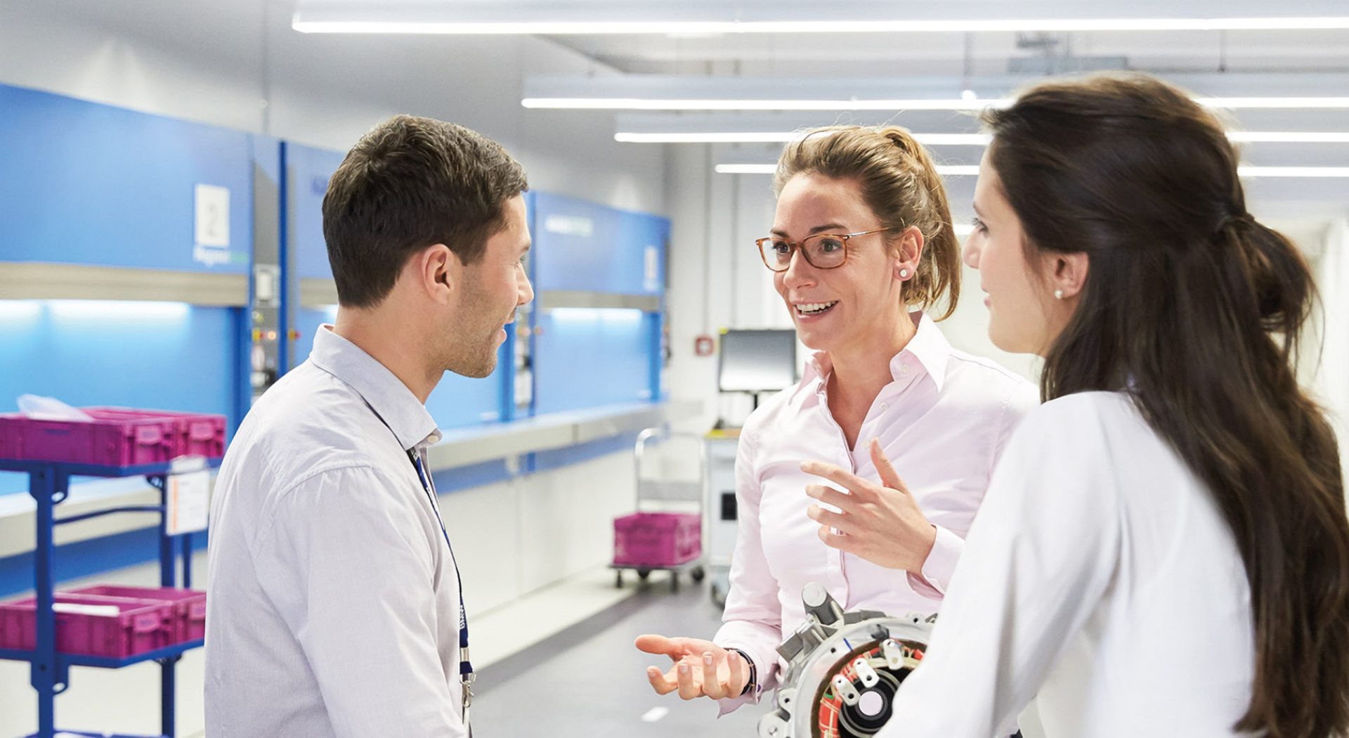 The picture shows three colleagues discussing.