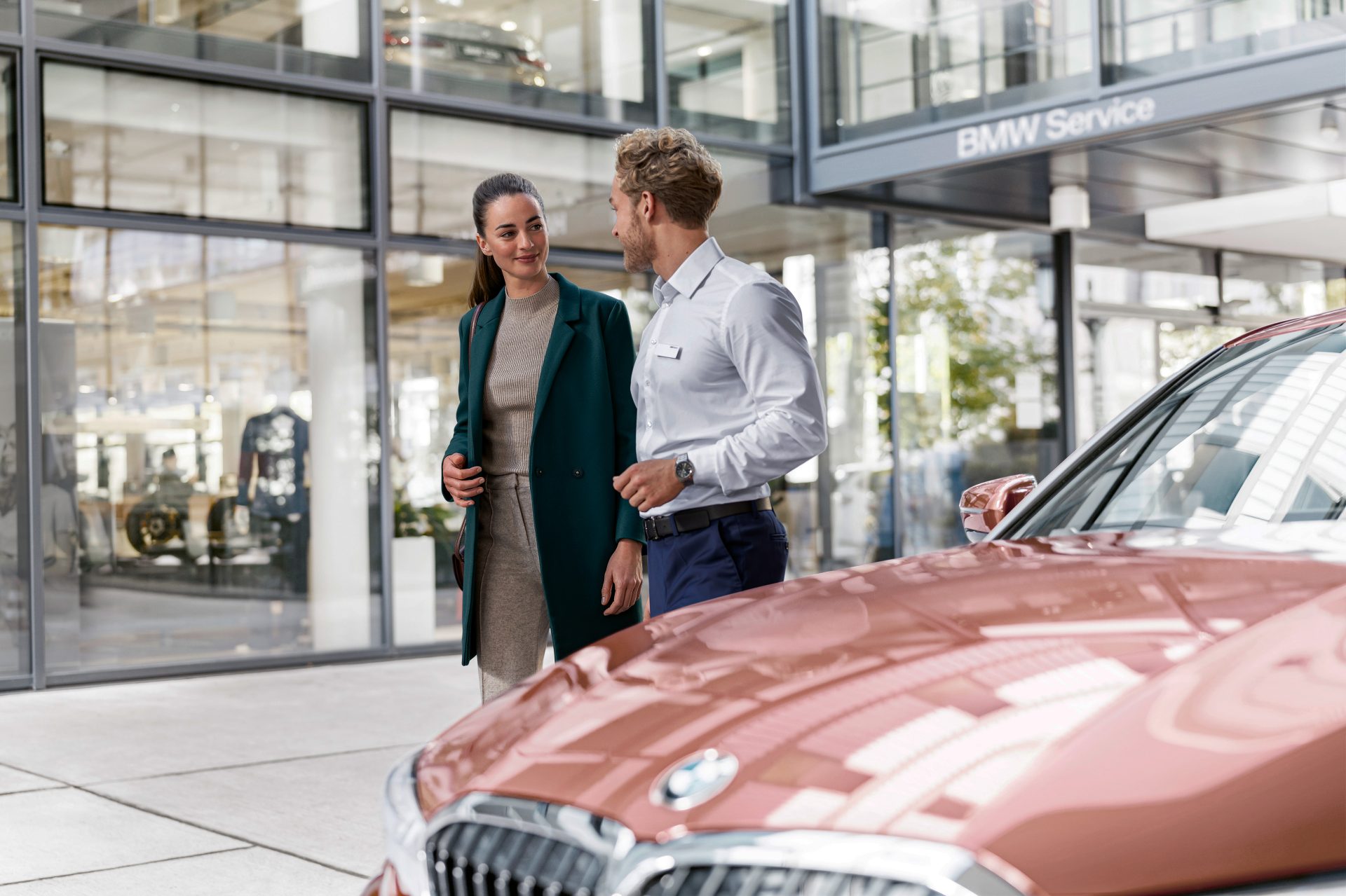 BMW employee talking to a customer in a BMW dealership.