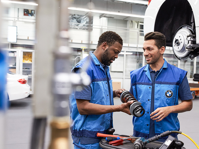 The picture represents the job culture by showing two BMW production employees.