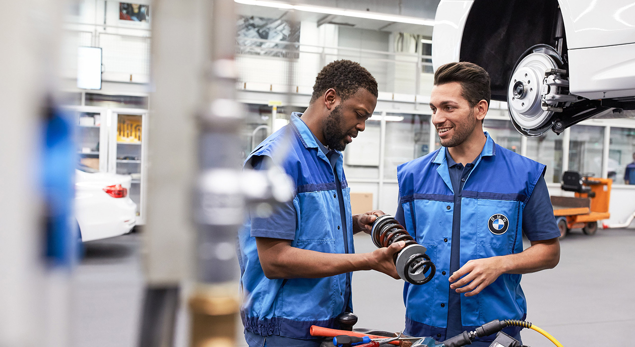 The picture represents the job culture by showing two BMW production employees.