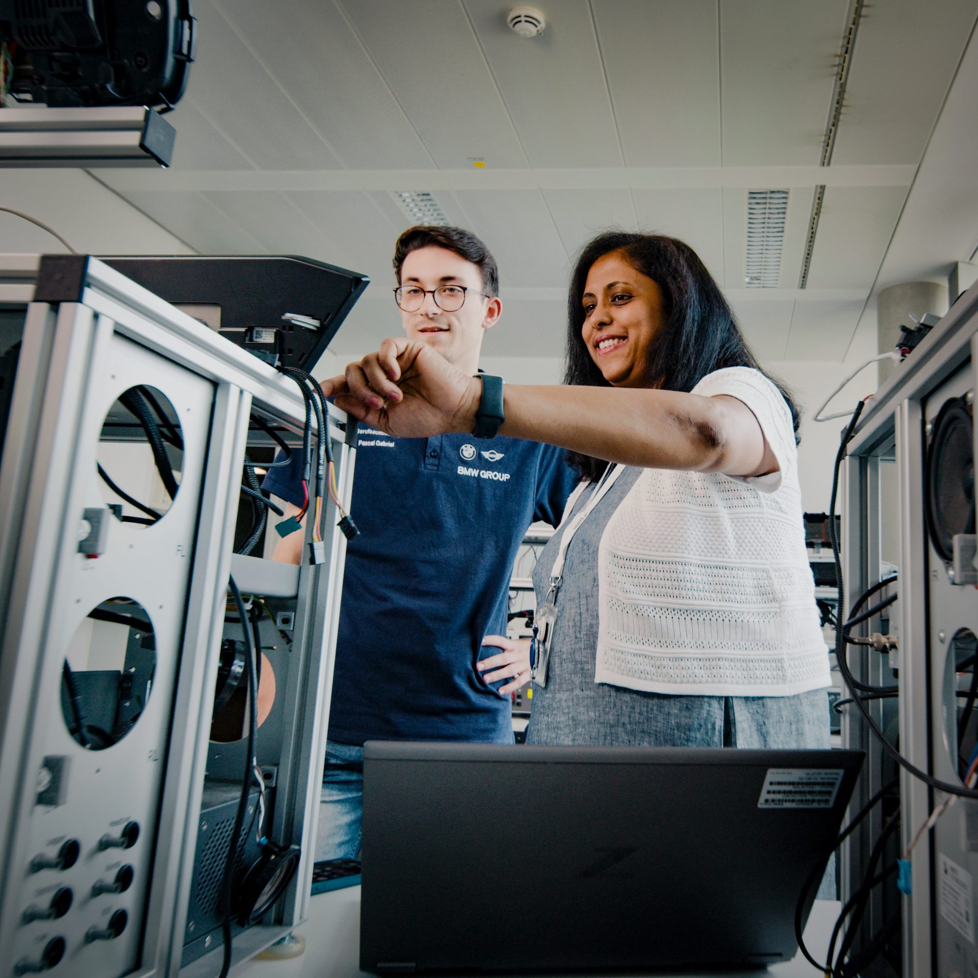 A female Specialist for Base System in exchange with a colleague at a test rack.