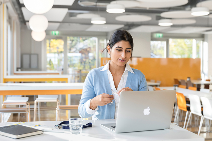 a young woman working on her laptop at a BMW office