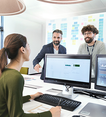 Three BMW professionals, a female one and two male ones, are meeting in an office to discuss a new project.