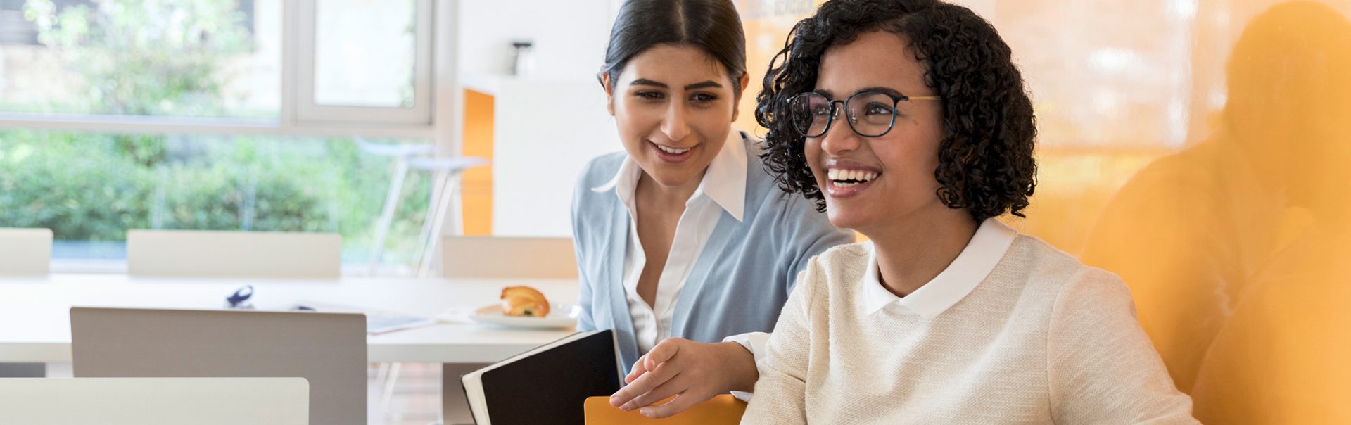 Two women laughing while working at BMW.