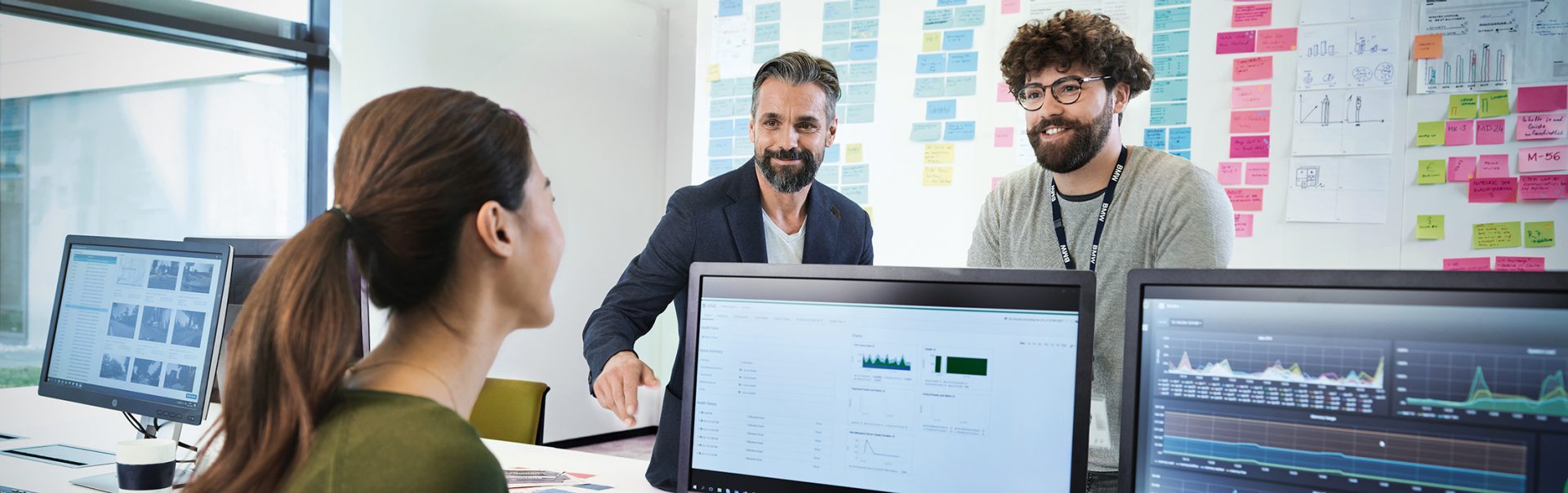 Three BMW professionals, a female one and two male ones, are meeting in an office to discuss a new project.