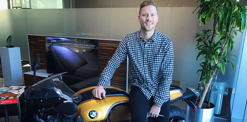 The image shows Alex Welsh, a Motorrad Marketing Coordinator at the BMW Group Canada.