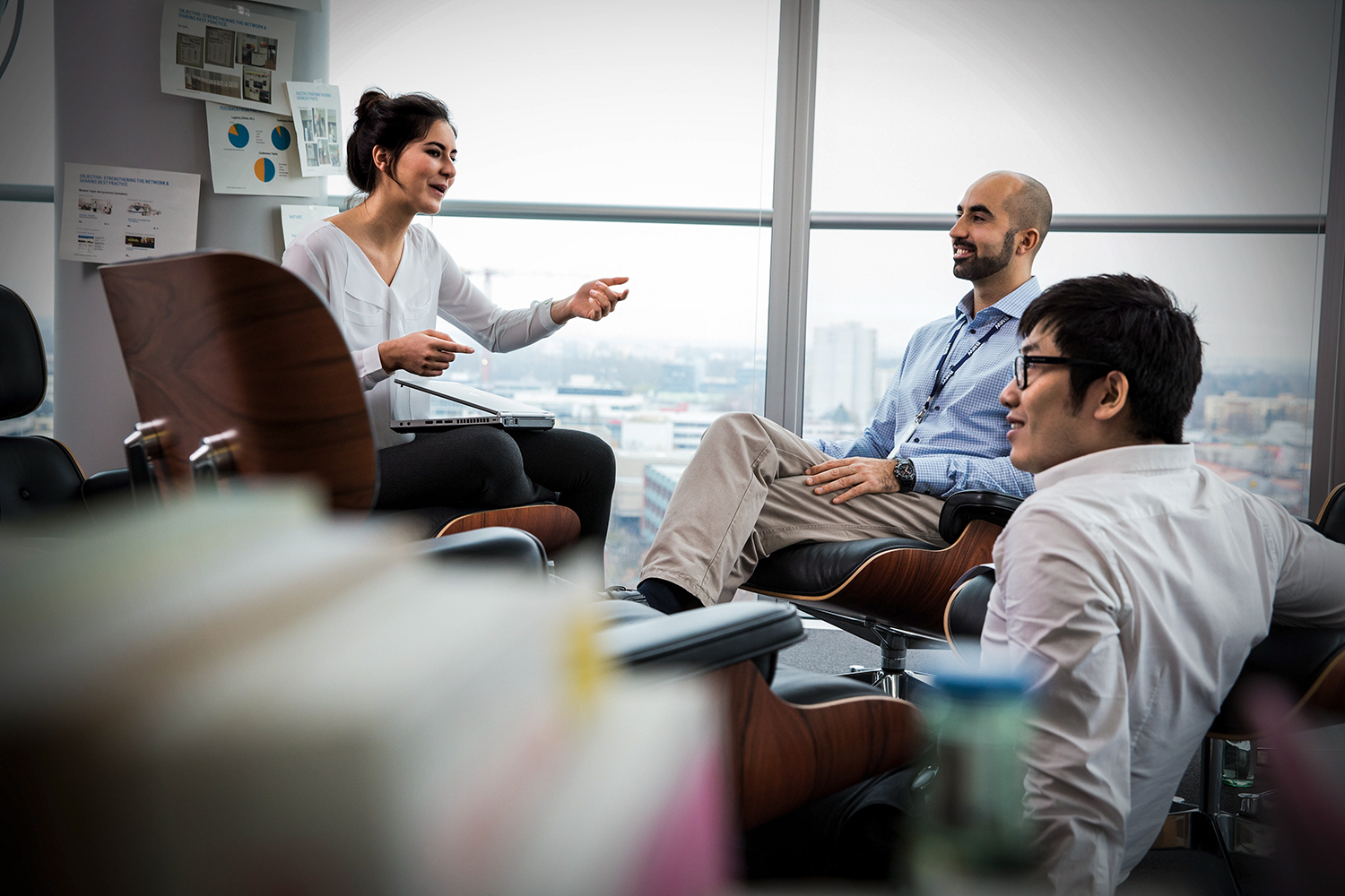 Three colleagues having a conversation in a meeting room