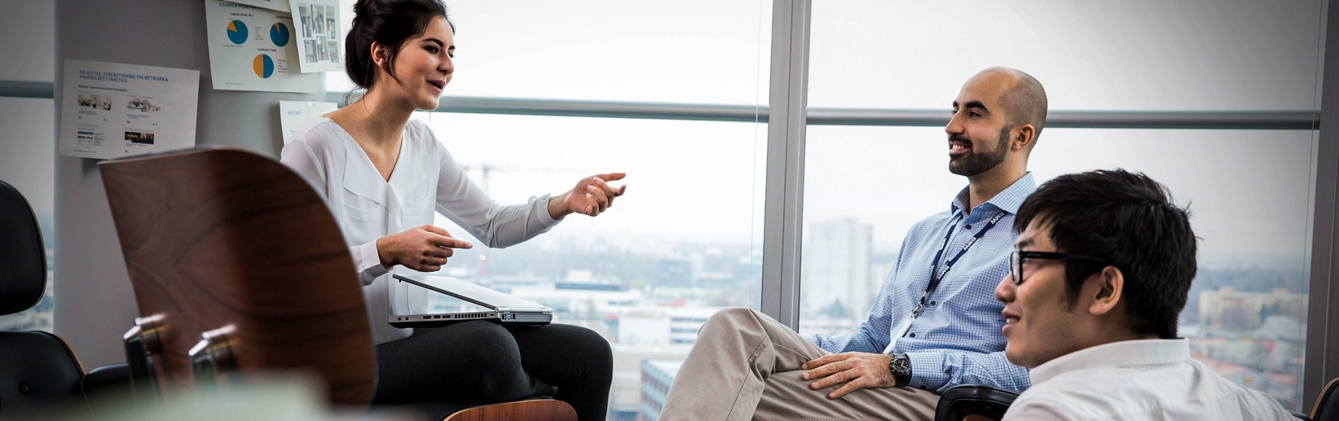 Three colleagues having a conversation in a meeting room