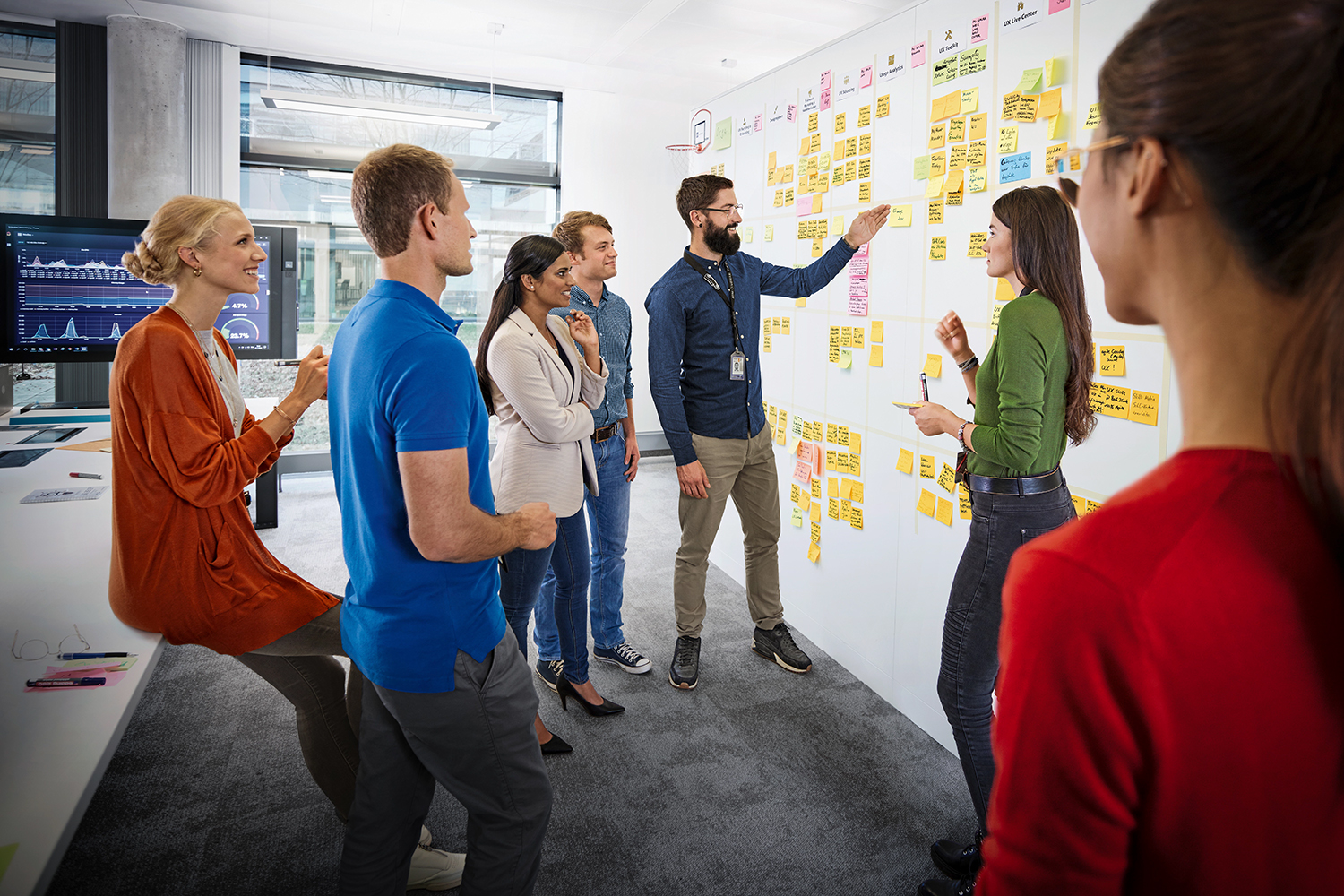 Seven colleagues analysing data on an agile project board