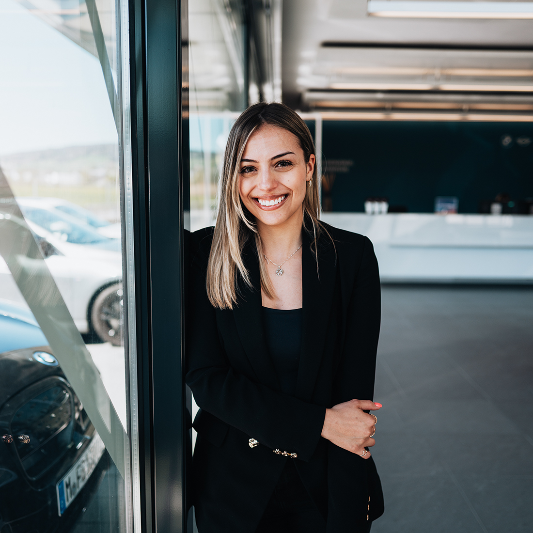 BMW Mitarbeiterin Melanie lächelnd im Foyer des Office Gebäudes der BMW Group in Dielsdorf