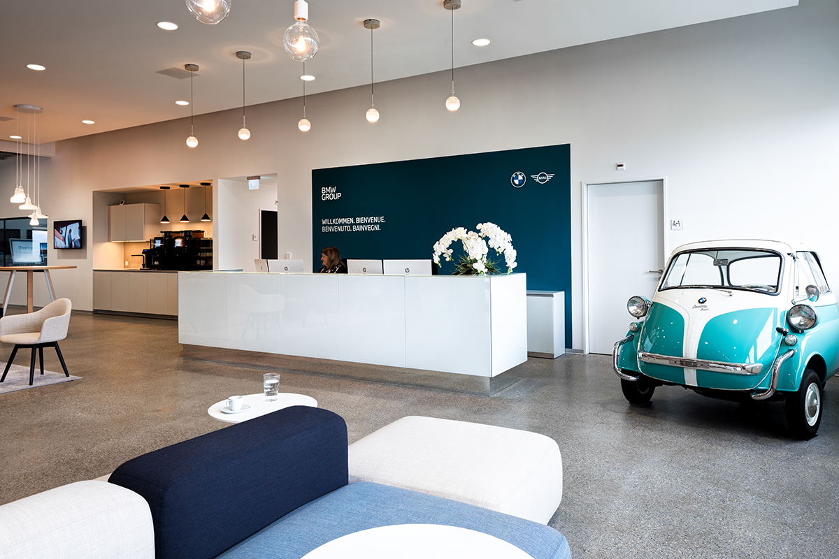 Trainingscenter Zofingen Entrance area with a reception, behind it a welcome sign and a blue BMW Isetta