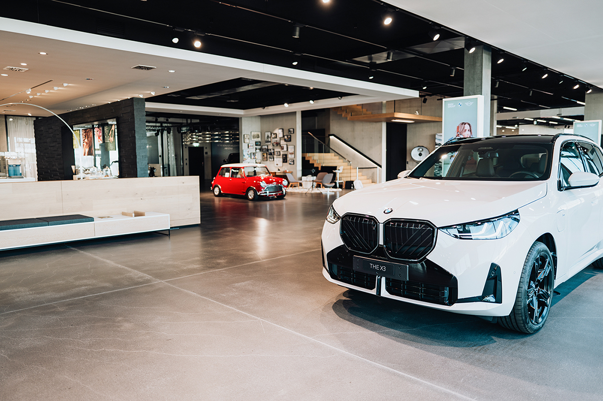 Headquarter Dielsdorf BMW group Showroom with a white BMW and a historical red MINI inside.