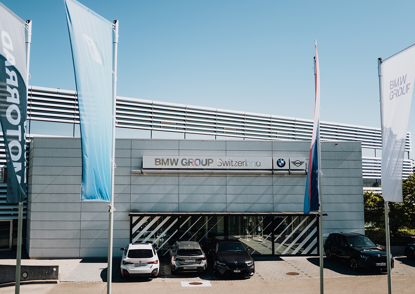 Exterior view of BMW Group Switzerland headquarters Dielsdorf, Switzerland with BMW cars parked infront.