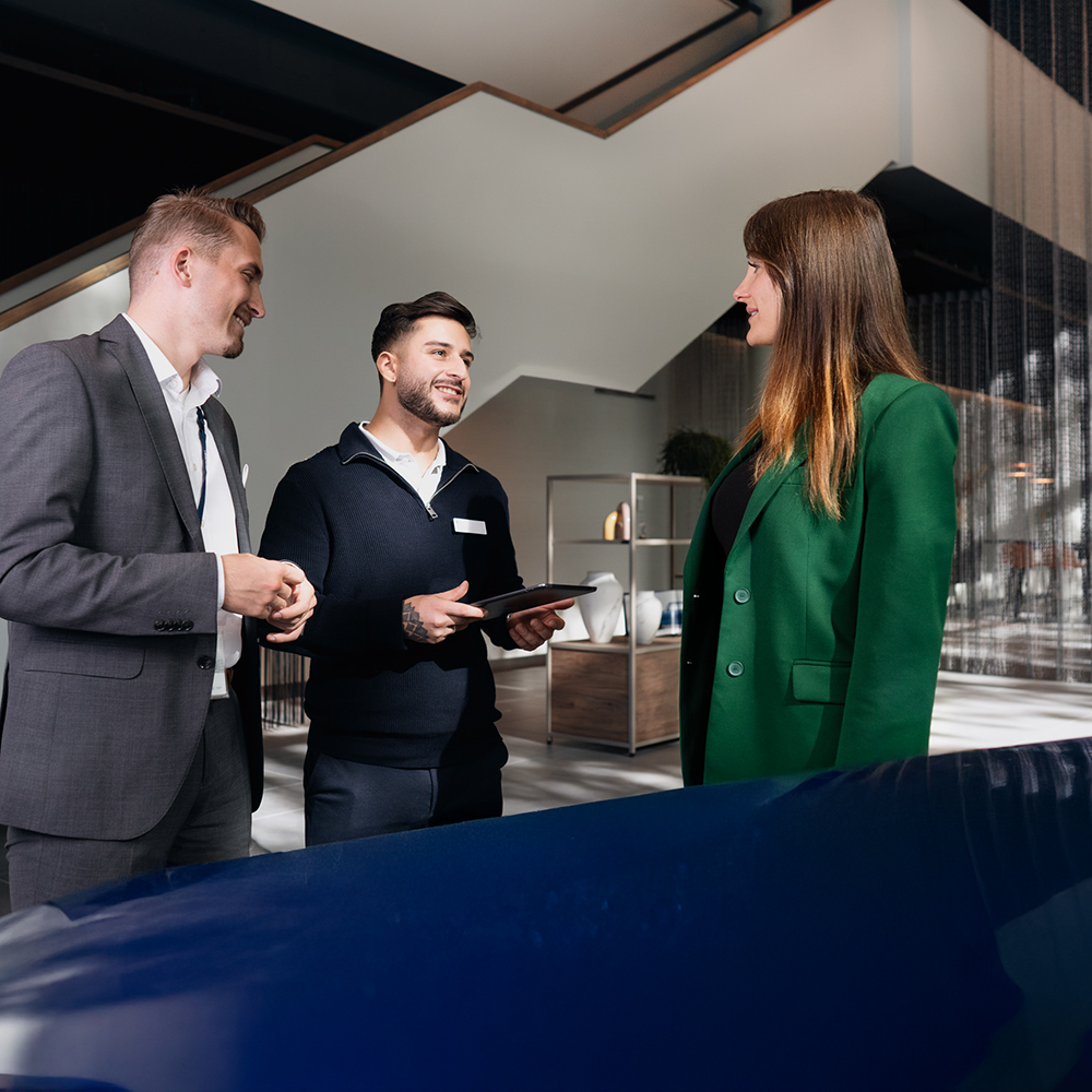 Two BMW salespeople conduct a sales talk with a customer