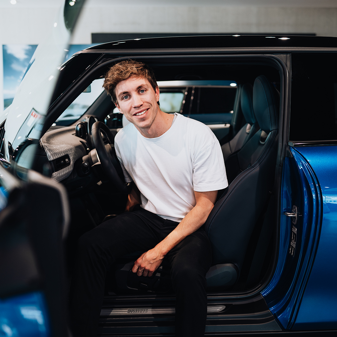 BMW employee in a blue MINI Cooper