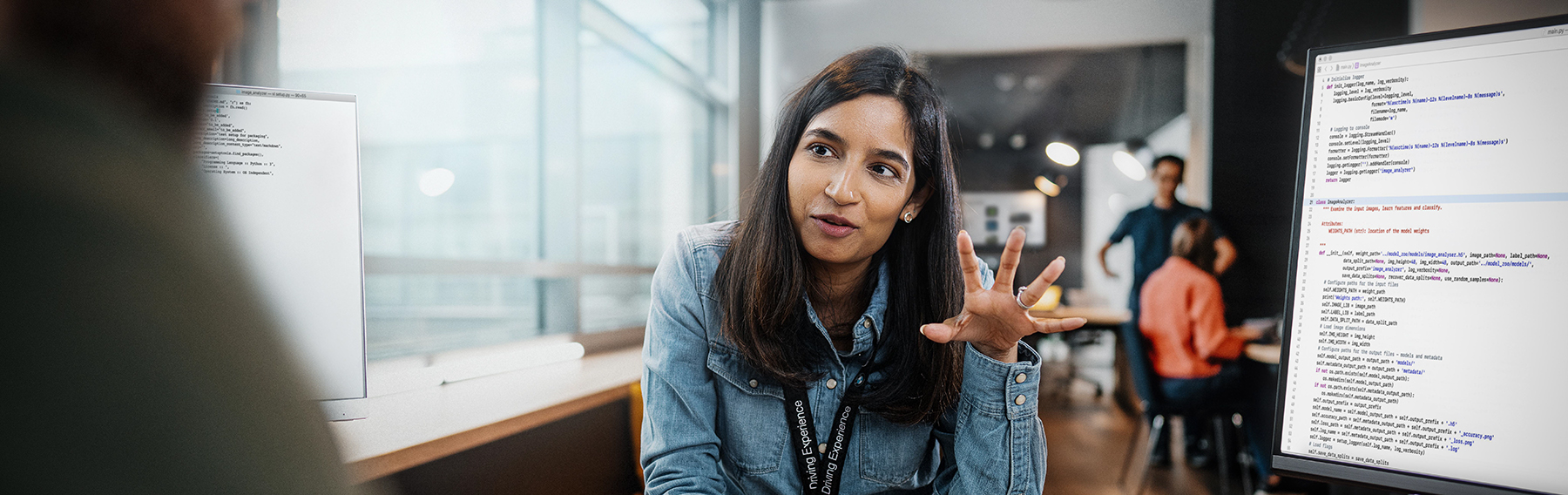 A colleague gestures while analyzing data on a screen