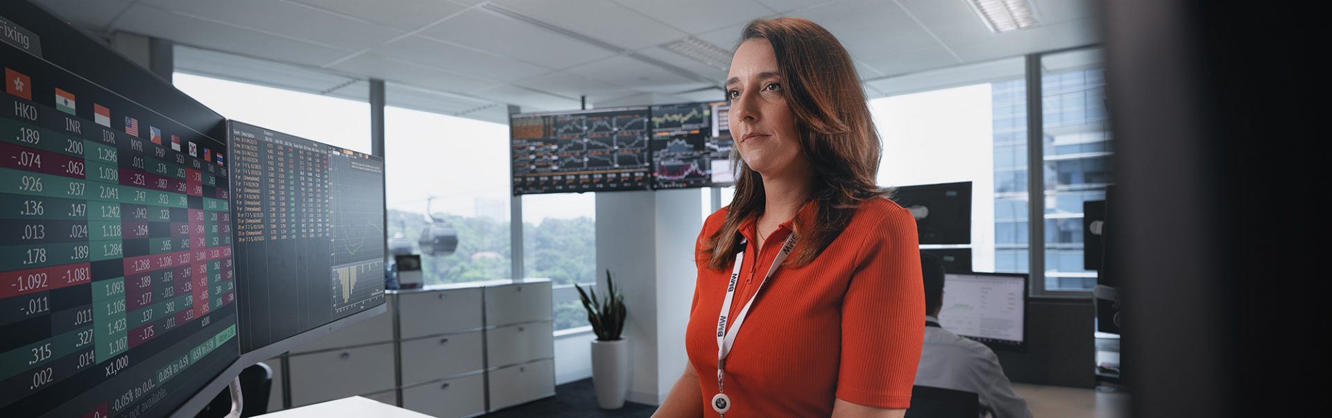 A colleague analyzing data on a computer with multiple screens