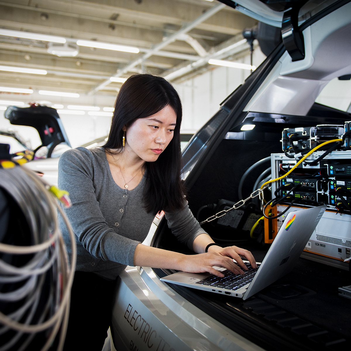 A female software developer works with hardware in the boot.