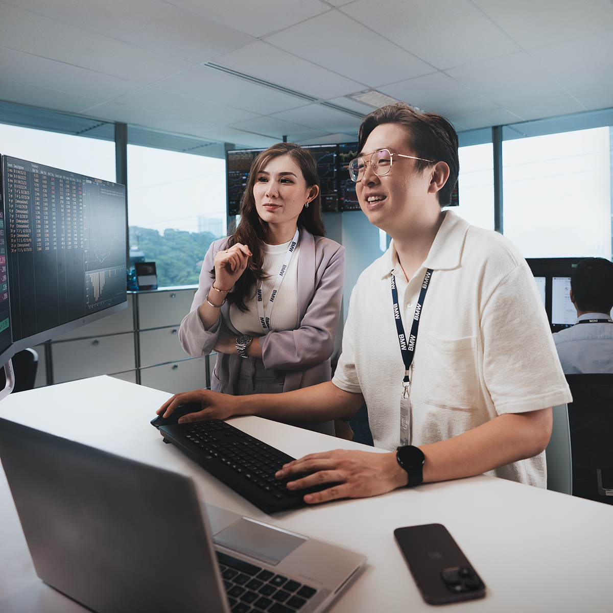 Two female business analysts are analysing data on a screen.