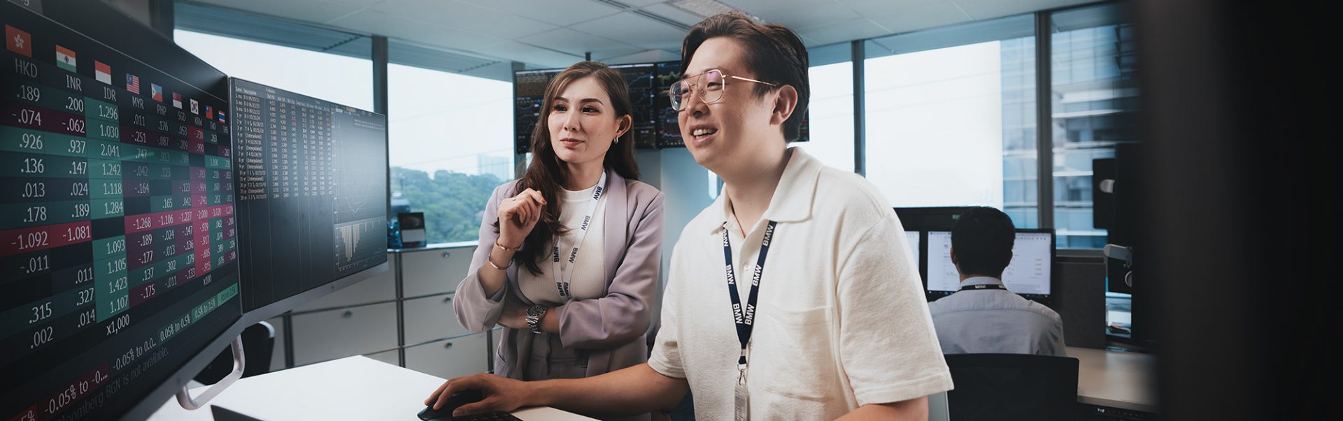 Two colleagues are analysing data on a screen.