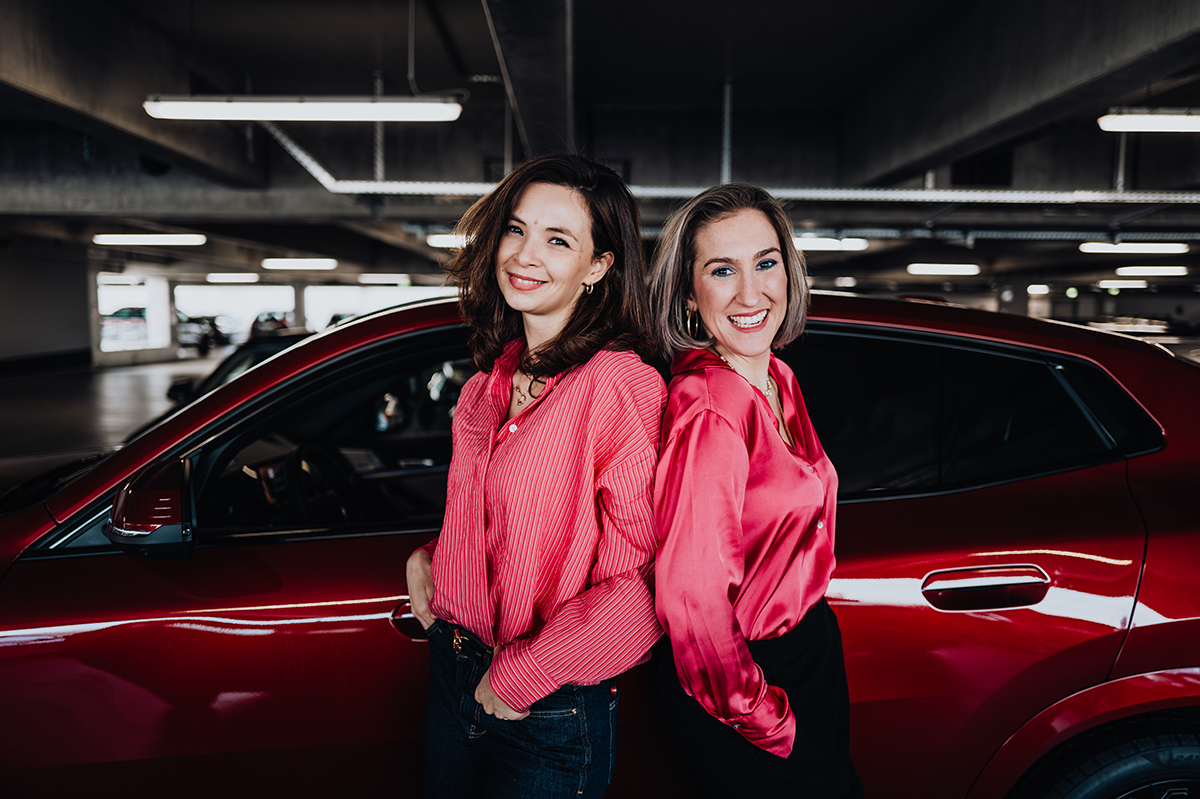 BMW Mitarbeiterinnen Julia und Denise vor einem roten BMW X2